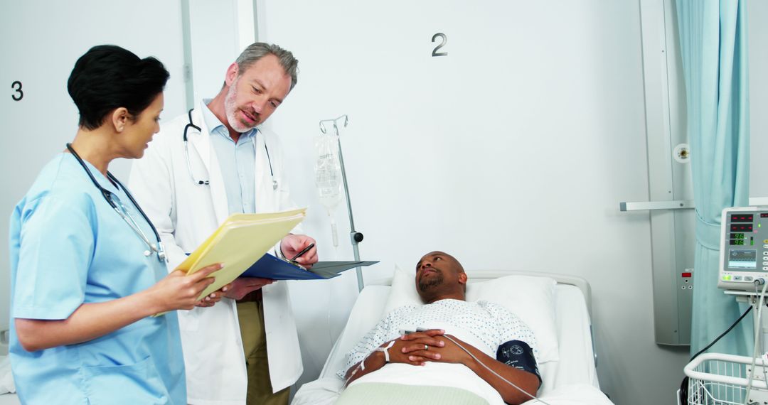 Doctors Discussing Medical Chart with Patient in Hospital Room - Free Images, Stock Photos and Pictures on Pikwizard.com