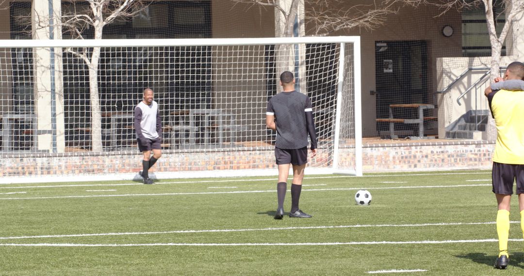 Soccer Players Strategizing Near Goal During Training Session
