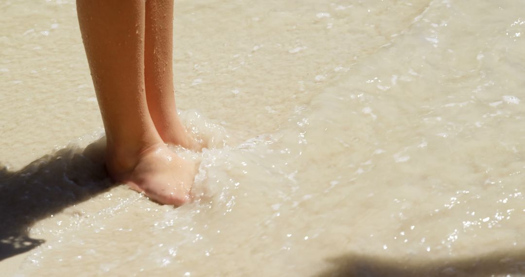 Legs of caucasian girl standing in water on sunny beach - Free Images, Stock Photos and Pictures on Pikwizard.com