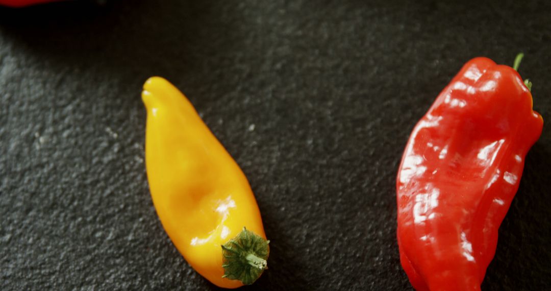 Closeup of Fresh Red and Yellow Peppers on Dark Slate - Free Images, Stock Photos and Pictures on Pikwizard.com