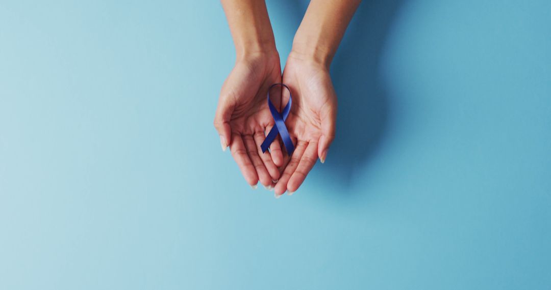 Female Hands Holding Blue Awareness Ribbon on Light Blue Background - Free Images, Stock Photos and Pictures on Pikwizard.com