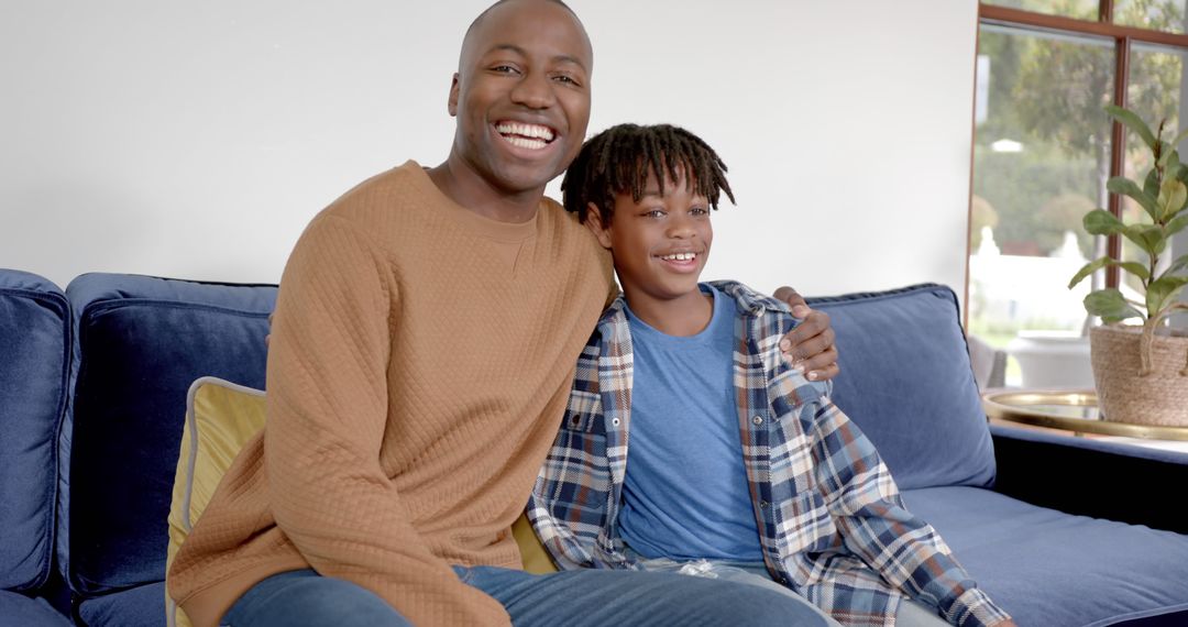 Smiling Father and Son Relaxing on Blue Sofa at Home - Free Images, Stock Photos and Pictures on Pikwizard.com