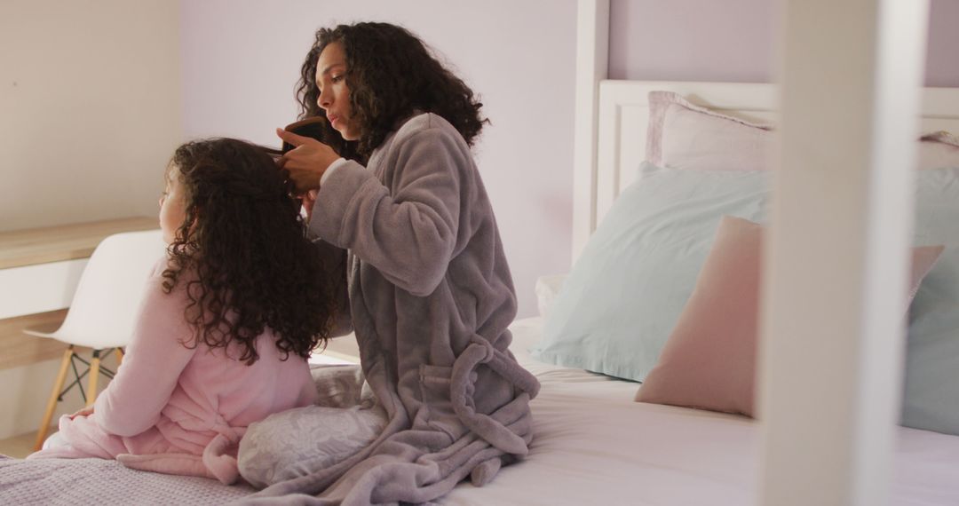 Biracial mother and daughter brushing hair in bedroom - Free Images, Stock Photos and Pictures on Pikwizard.com