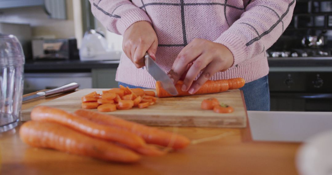 Woman Chopping Carrots in Modern Kitchen - Free Images, Stock Photos and Pictures on Pikwizard.com