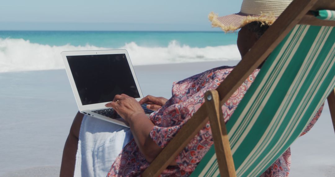 Senior Woman Working on Laptop While Relaxing at Beach - Free Images, Stock Photos and Pictures on Pikwizard.com