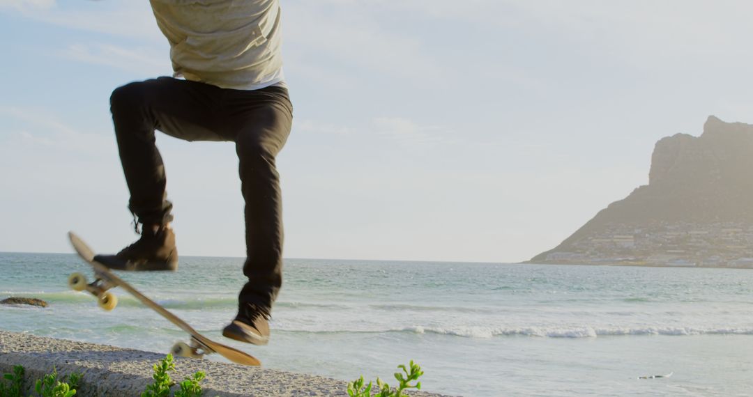 Young Man Skateboarding by Scenic Ocean View with Mountain