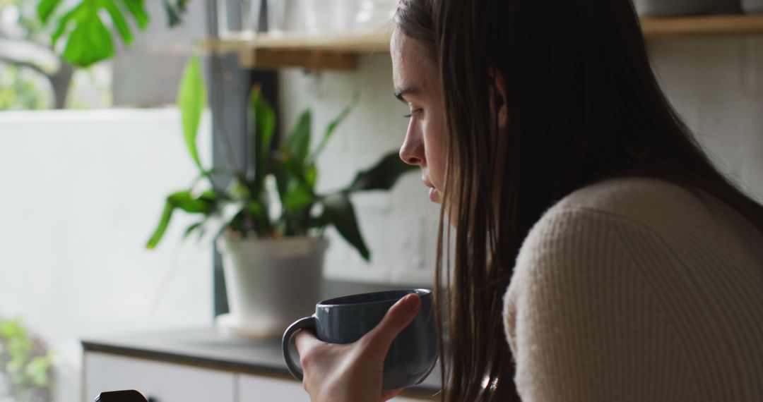 Woman Relaxing with Coffee Cup in Modern Kitchen - Free Images, Stock Photos and Pictures on Pikwizard.com