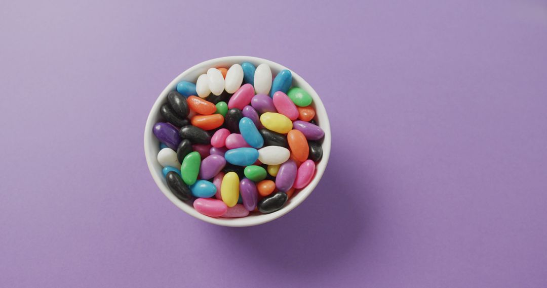 Colorful Jelly Beans in White Bowl on Purple Background - Free Images, Stock Photos and Pictures on Pikwizard.com