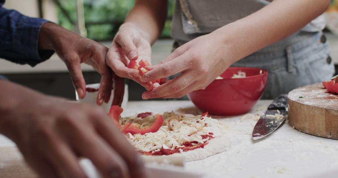 Hands Preparing Homemade Pizza with Fresh Ingredients in Kitchen - Free Images, Stock Photos and Pictures on Pikwizard.com