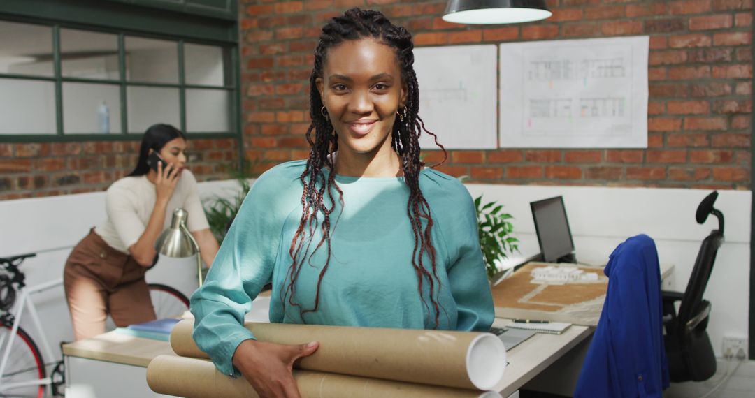 Confident Female Architect Holding Blueprints in Modern Office - Free Images, Stock Photos and Pictures on Pikwizard.com