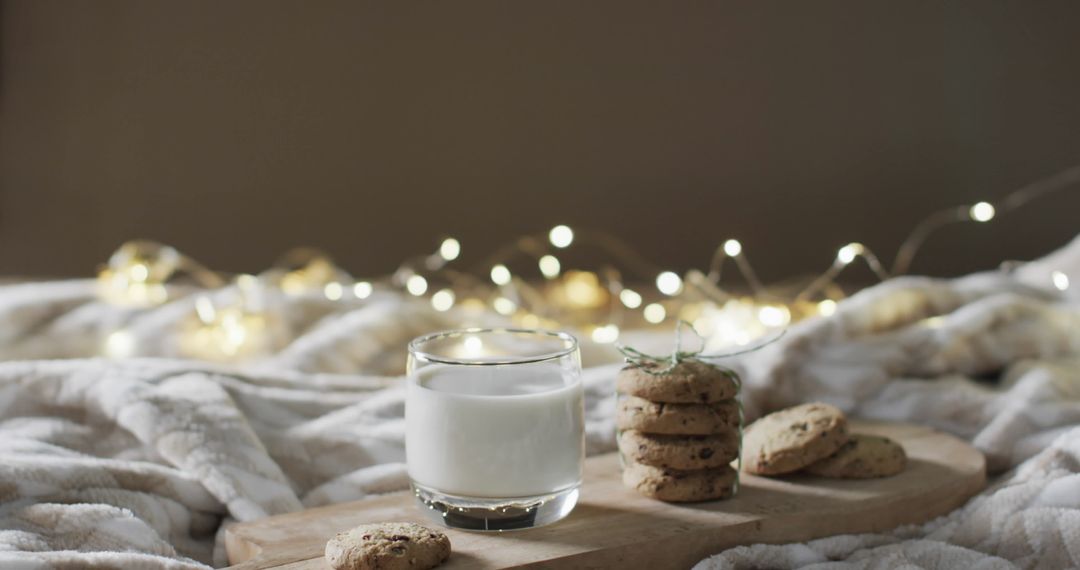 Glass of Milk and Chocolate Chip Cookies in Cozy Bed Setting
