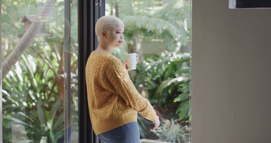 Woman Holding Coffee Cup Enjoying Morning Relaxation by Glass Door - Free Images, Stock Photos and Pictures on Pikwizard.com