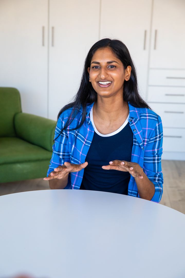 Indian Woman Smiling and Gesturing in Cozy Interior Setting