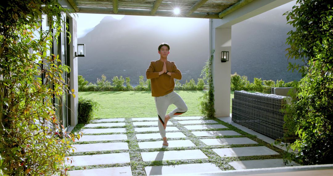 Man Practicing Tree Pose on Tranquil Patio with Mountain View