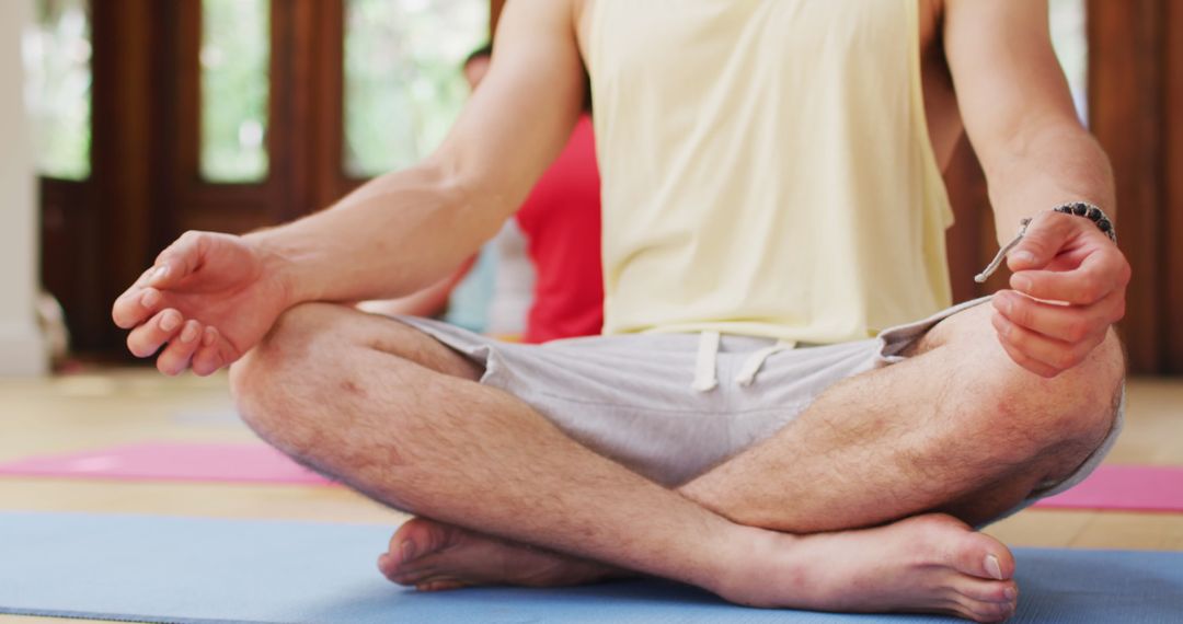 Close-up Man Meditating in Lotus Pose During Yoga Class