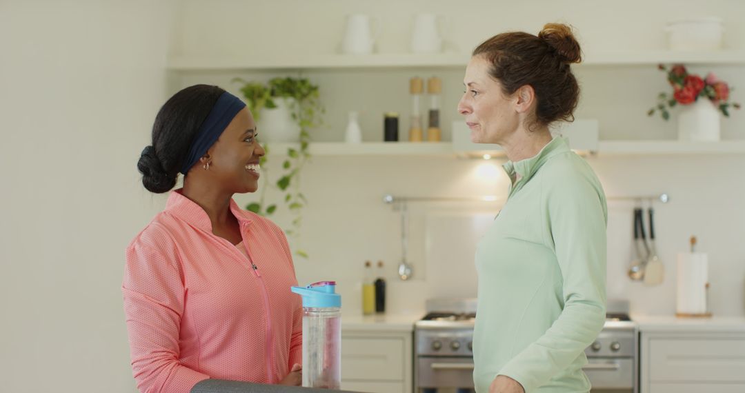 Diverse Workout Partners Engaging in Active Kitchen Conversation