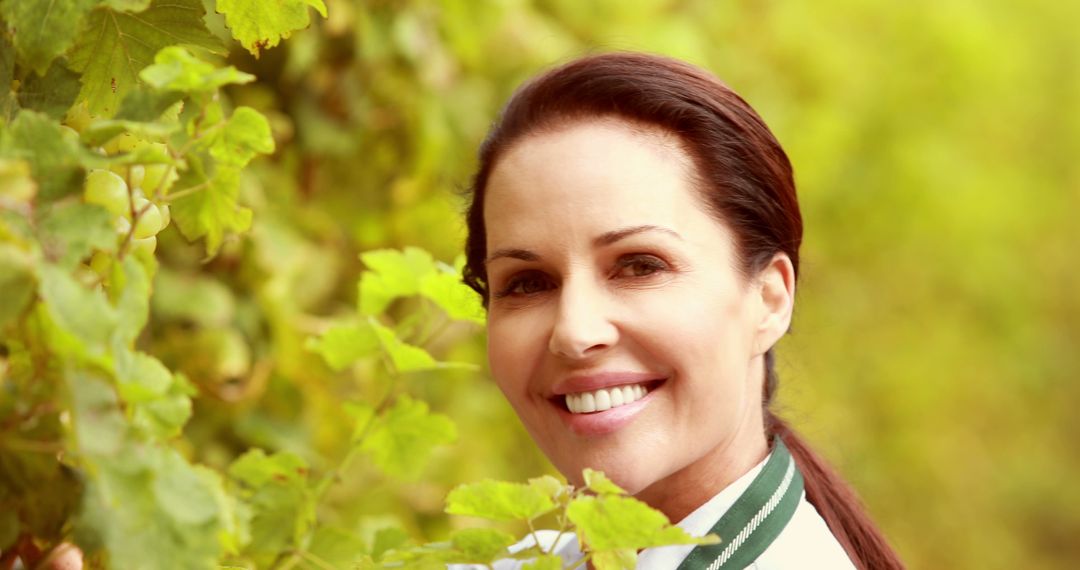 Smiling Woman in Vineyard Amongst Green Leaves - Free Images, Stock Photos and Pictures on Pikwizard.com