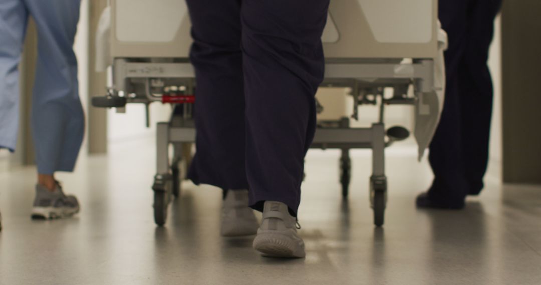 Medical Staff Pushing Hospital Bed through Corridor - Free Images, Stock Photos and Pictures on Pikwizard.com