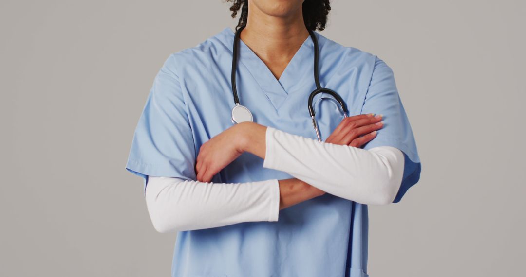 Image of smiling biracial female doctor with arms crossed on blue background - Free Images, Stock Photos and Pictures on Pikwizard.com