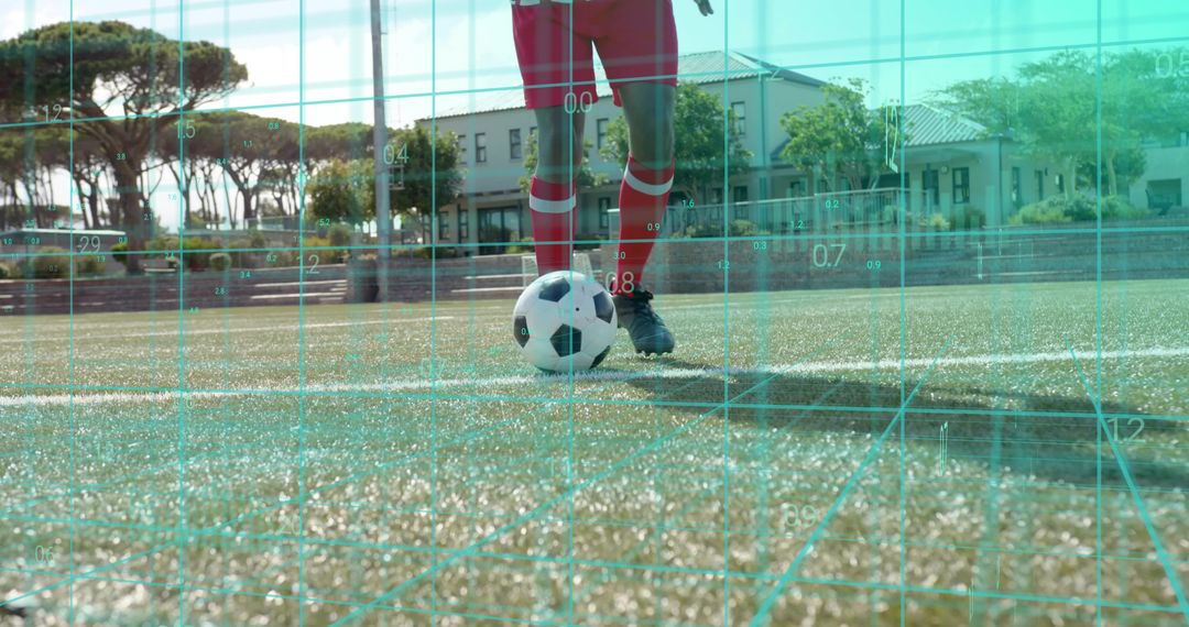 Soccer player controlling ball on turf wearing red kit with cyan AR grid for performance analysis