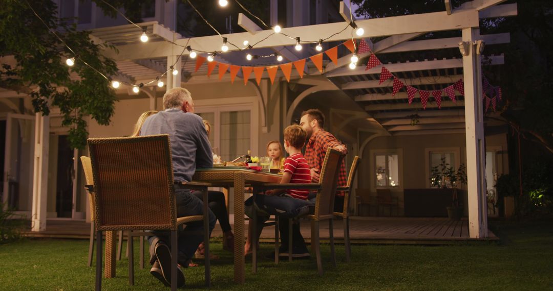 Family Enjoying Outdoor Dinner in Backyard Under String Lights