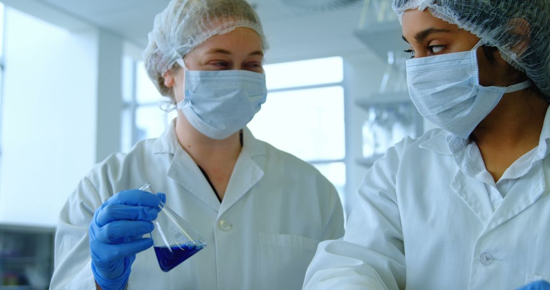 Two Scientists in Lab Analyzing Blue Liquid with Copy Space