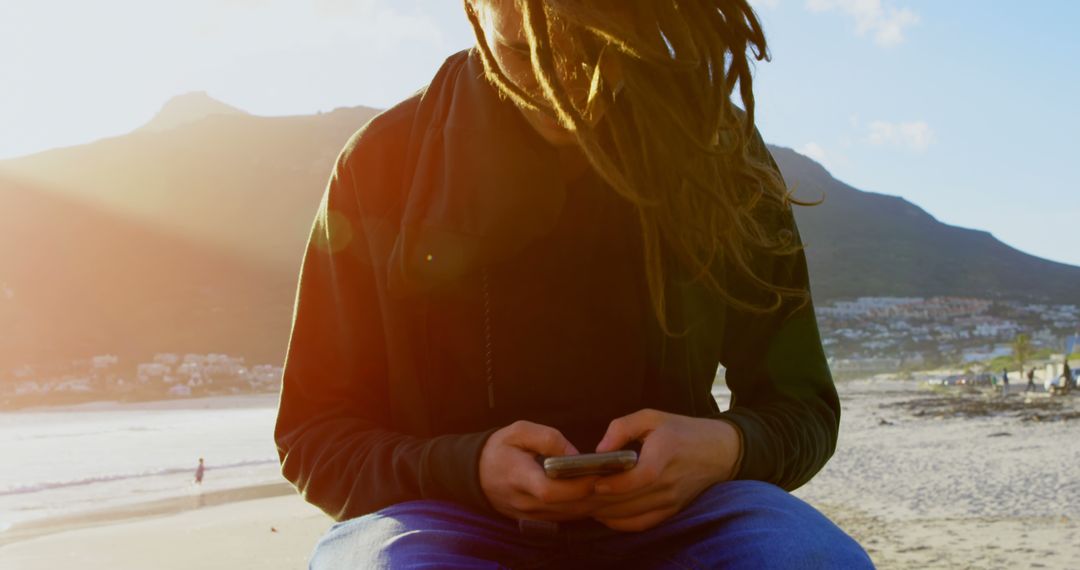 Man with Dreadlocks Using Smartphone at Beach - Free Images, Stock Photos and Pictures on Pikwizard.com