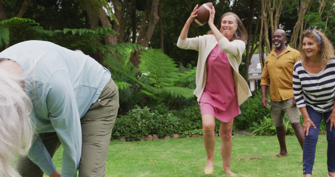 Image of happy diverse female and male senior friends playing american football in garden - Free Images, Stock Photos and Pictures on Pikwizard.com
