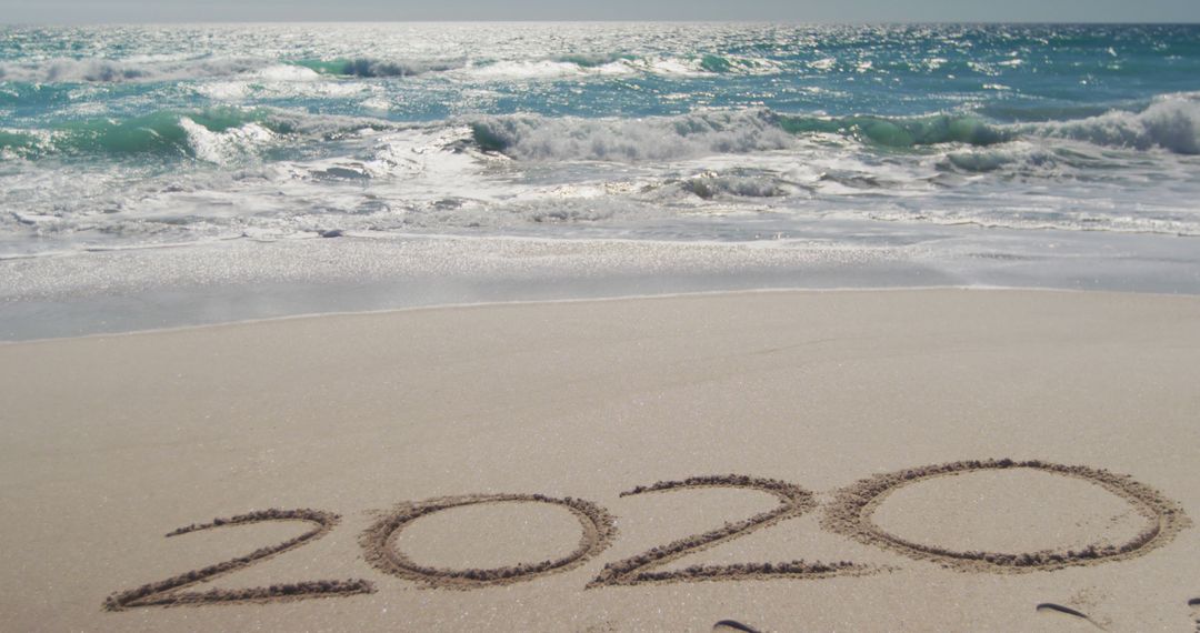 2020 written in sand on beach with ocean waves - Free Images, Stock Photos and Pictures on Pikwizard.com