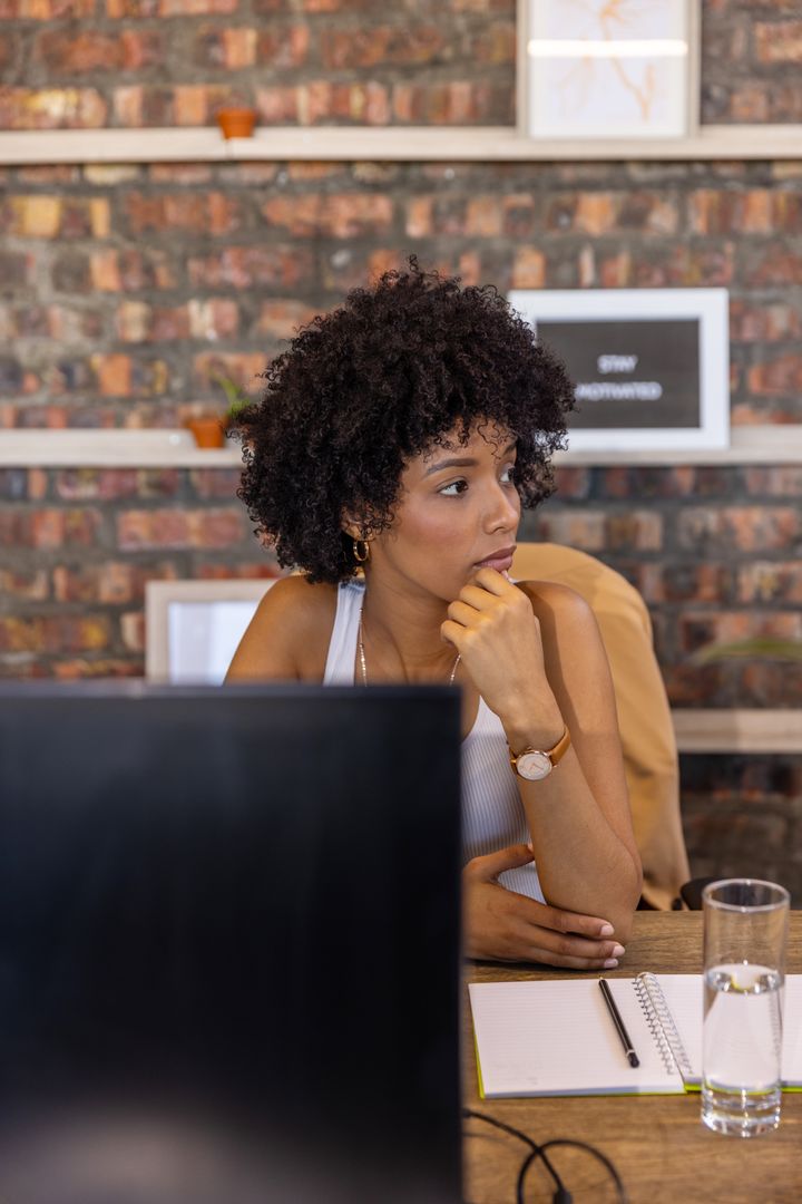 Thoughtful African American Woman in Modern Industrial Office Setting