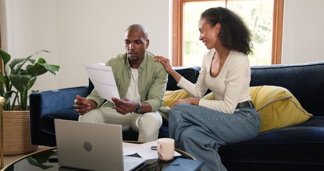 Diverse Couple Discussing Plans with Laptop at Home