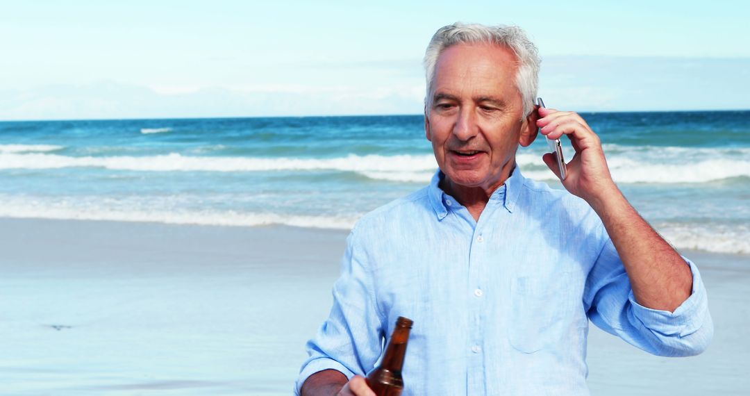 Senior Man Enjoying Beach Holding Beer and Talking on Phone - Free Images, Stock Photos and Pictures on Pikwizard.com