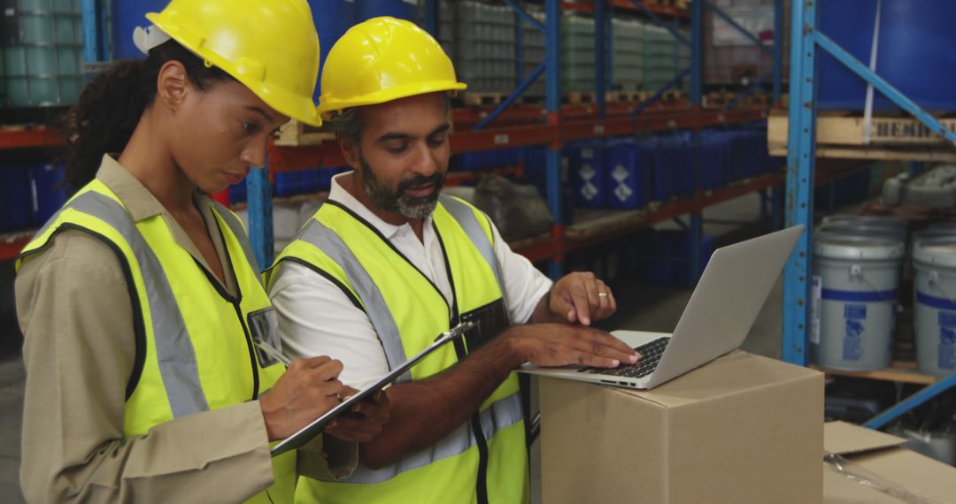 Warehouse Workers Using Laptop and Clipboard for Inventory Management - Free Images, Stock Photos and Pictures on Pikwizard.com