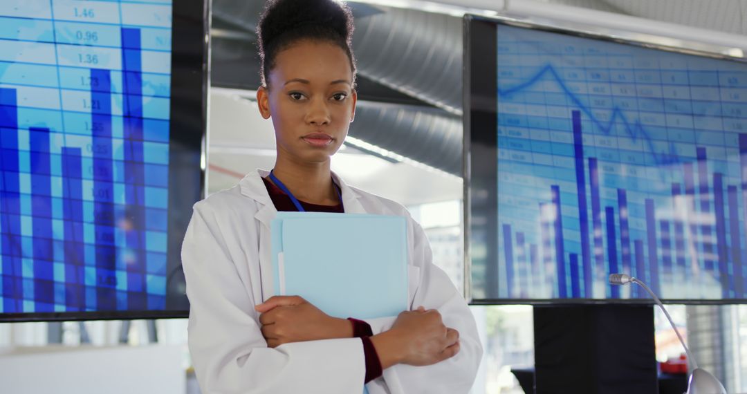 Confident Scientist Holding a Folder in Tech Lab with Data Charts Background - Free Images, Stock Photos and Pictures on Pikwizard.com