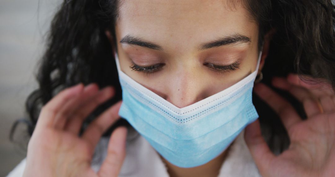 Close-up of Woman Adjusting Protective Face Mask for Safety - Free Images, Stock Photos and Pictures on Pikwizard.com