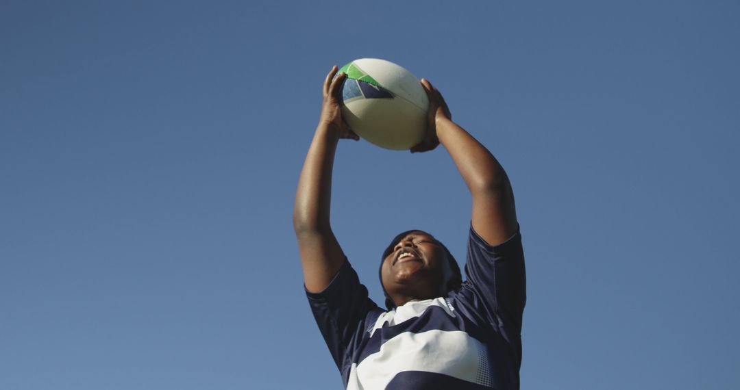 Rugby Player Catching Ball under Clear Blue Sky - Free Images, Stock Photos and Pictures on Pikwizard.com