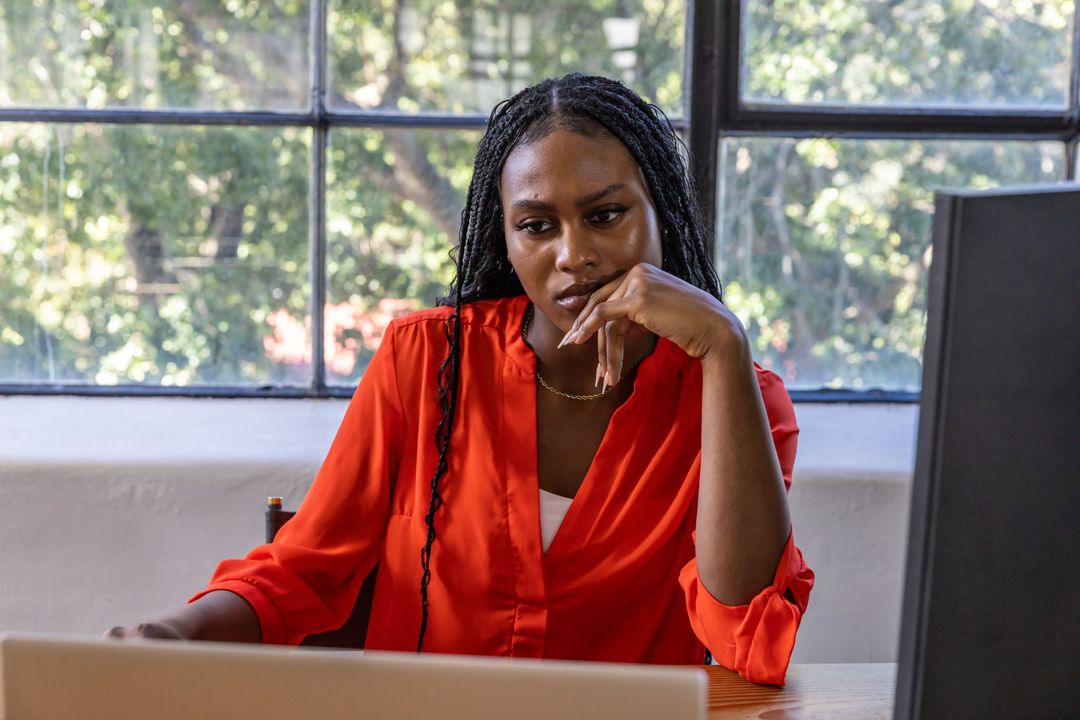 Focused Professional Managing Dual Screens in Home Office