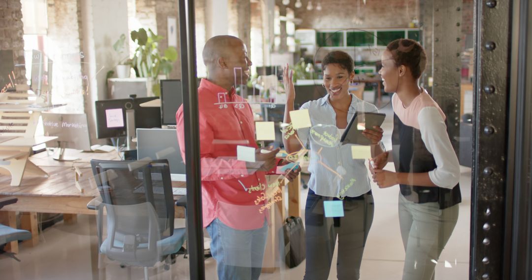 Diverse Team Brainstorming Behind Glass Wall at Modern Office