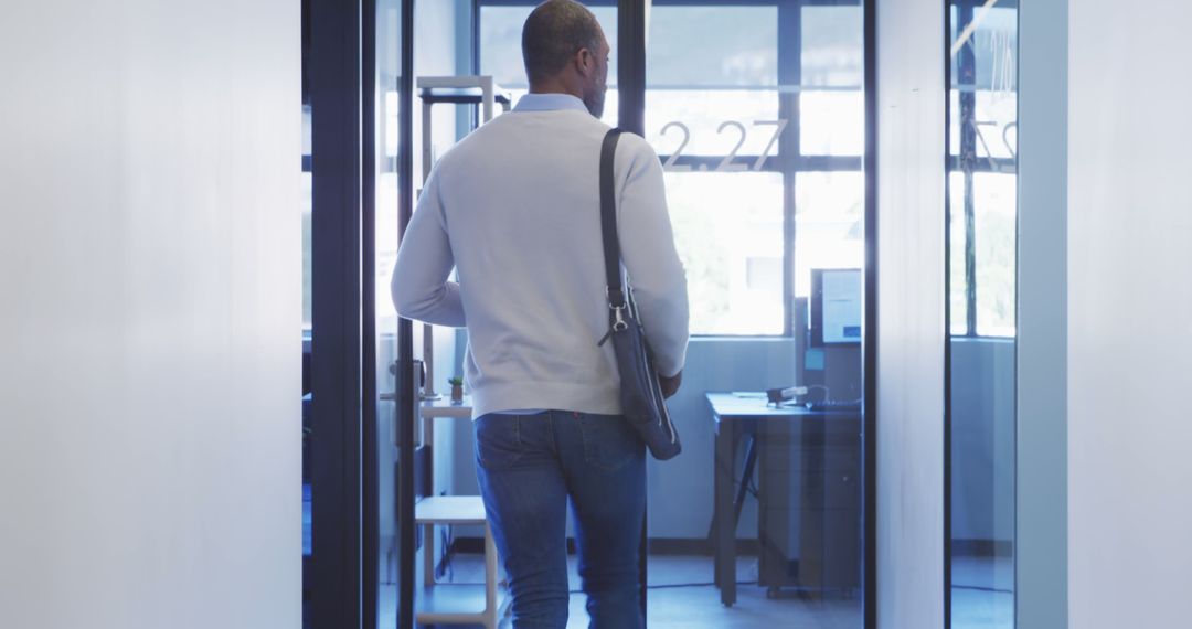 Businessman Walking Through Modern Office Corridor