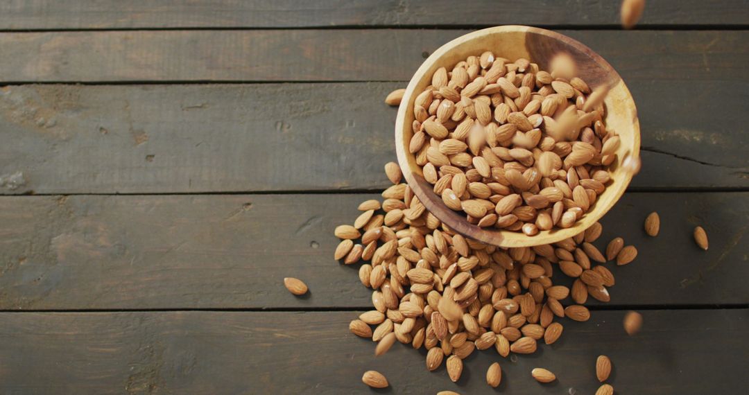 Overflowing Bowl of Fresh Almonds on Rustic Wooden Surface