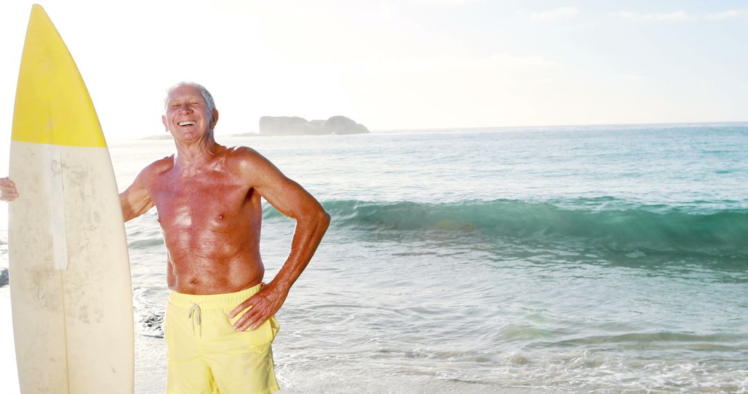 Senior Surfer Standing with Surfboard on Sunny Beach - Free Images, Stock Photos and Pictures on Pikwizard.com