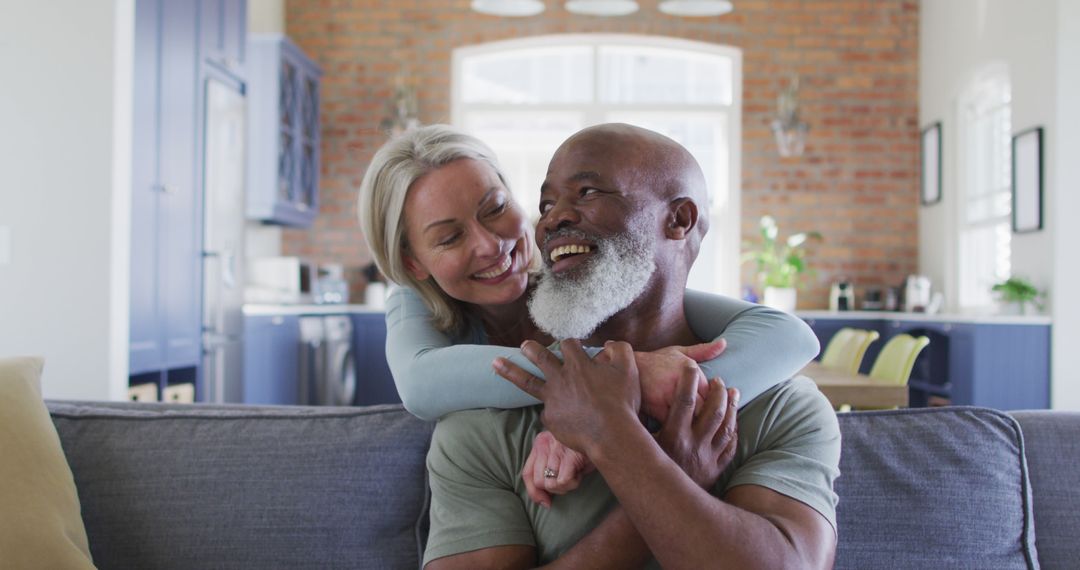 Portrait of biracial senior couple hugging each other and smiling at home - Free Images, Stock Photos and Pictures on Pikwizard.com