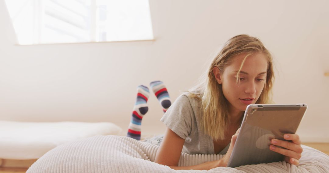 Woman Relaxing on a Beanbag Using Digital Tablet at Home