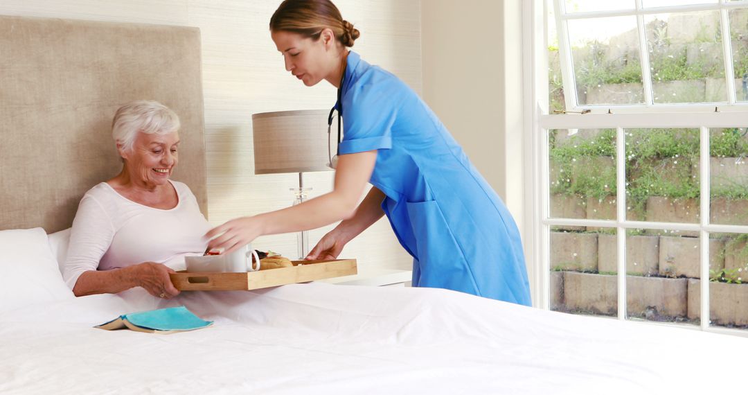 Healthcare worker serving meal to elderly woman in bedroom - Free Images, Stock Photos and Pictures on Pikwizard.com