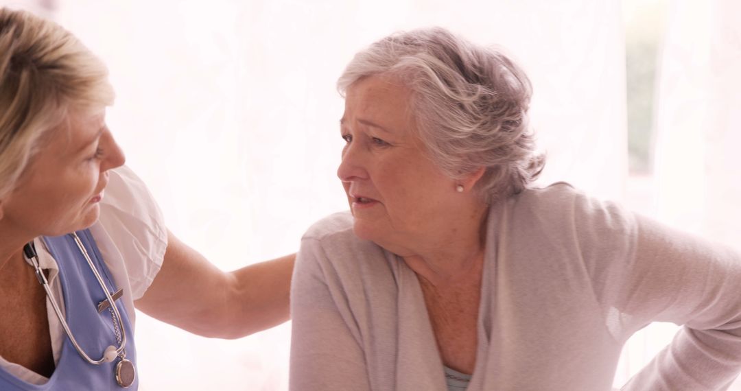 Nurse comforting elderly woman in light-colored room - Free Images, Stock Photos and Pictures on Pikwizard.com