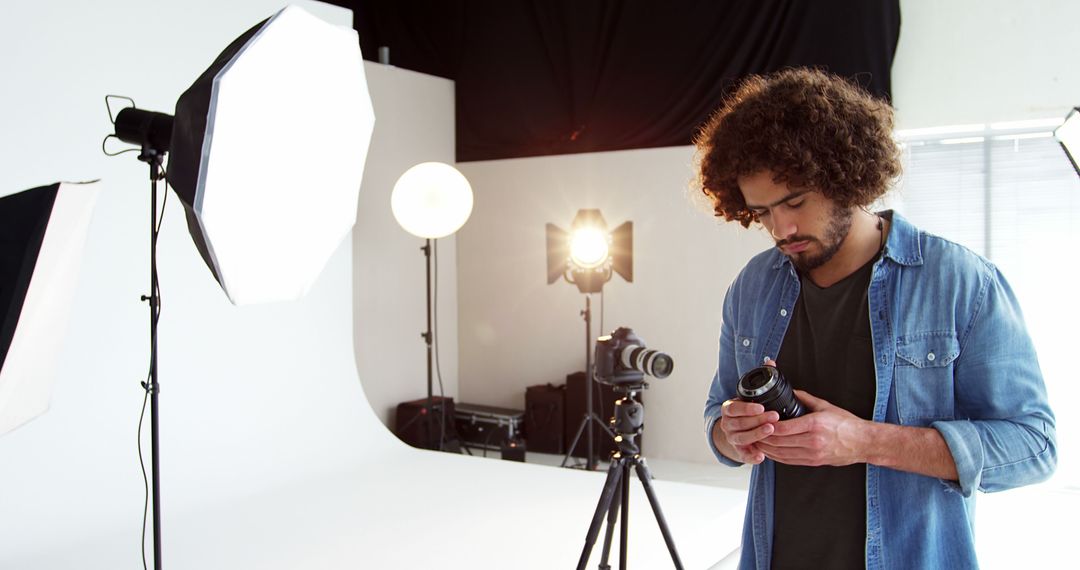 Male Photographer Adjusting Camera Lens in Studio - Free Images, Stock Photos and Pictures on Pikwizard.com