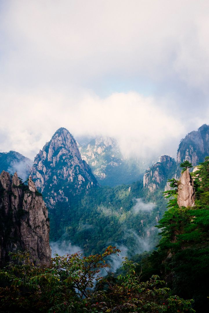 Scenic Mountain Peaks Amidst Misty Clouds in Serene Landscape - Free Images, Stock Photos and Pictures on Pikwizard.com