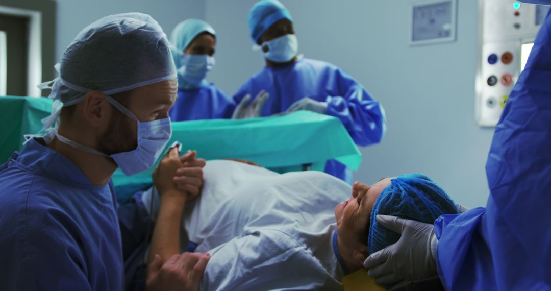 Side view of Caucasian man comforting woman during labor pain in operation theater at hospital - Free Images, Stock Photos and Pictures on Pikwizard.com