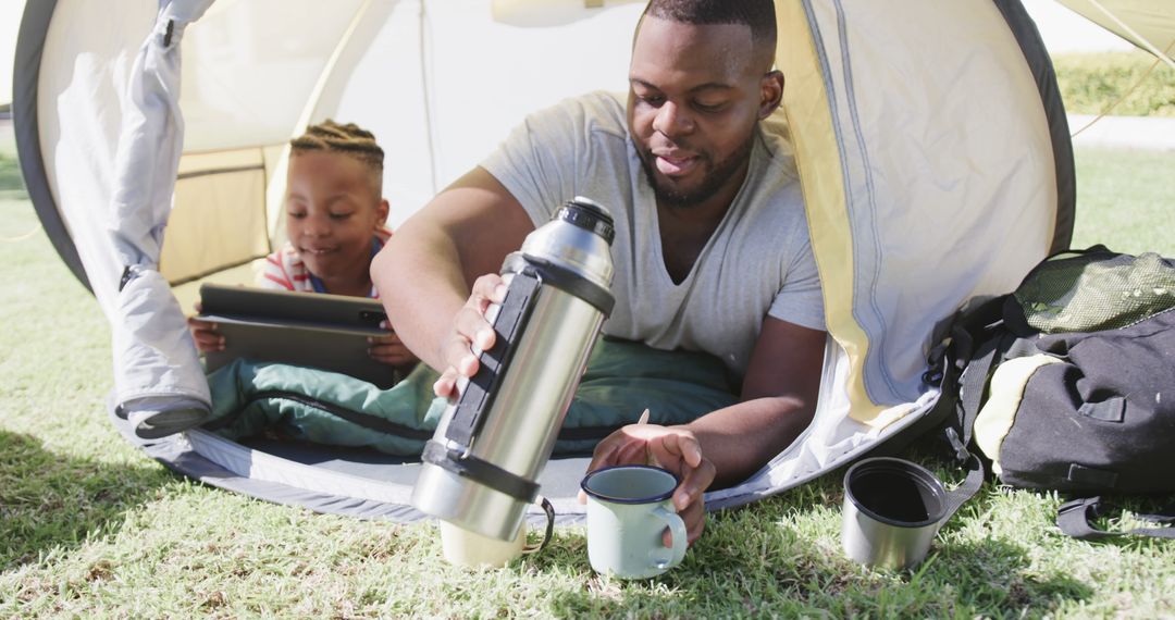 Father and Daughter Camping with Tablet and Thermos in Tent - Free Images, Stock Photos and Pictures on Pikwizard.com