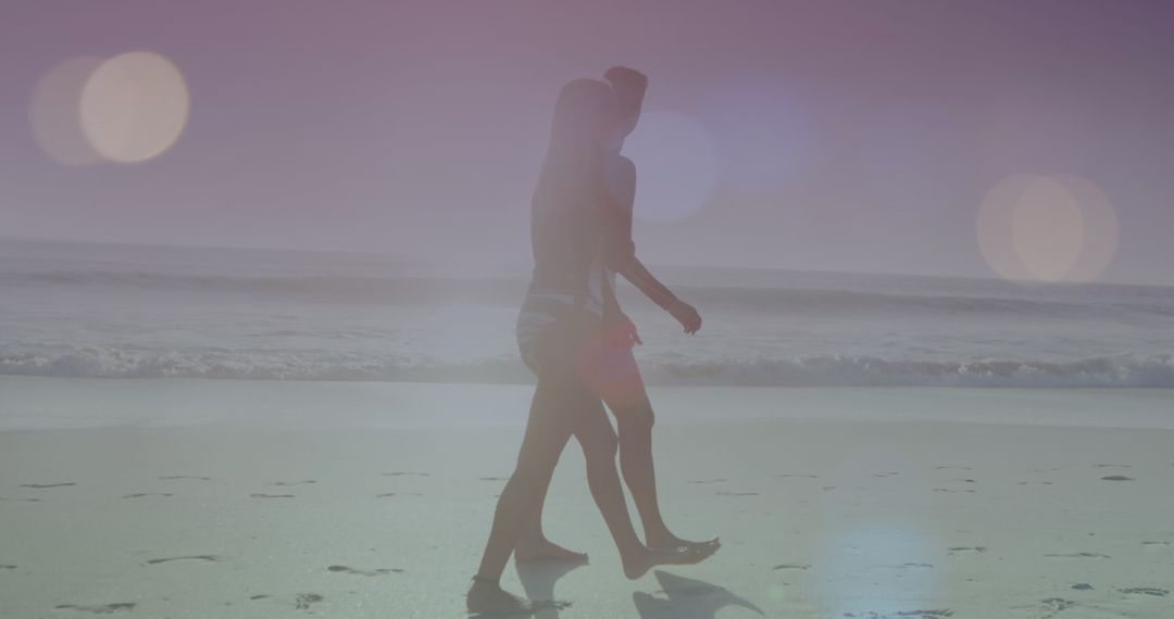 Romantic Couple Strolling Along Sunny Beach with Lens Flares